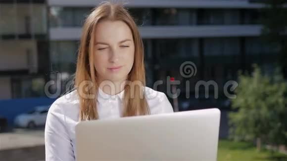 商务中心外使用笔记本电脑的美丽商务女性画像视频的预览图