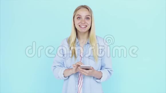 幸福的年轻女士站在蓝色背景上孤立的形象视频的预览图