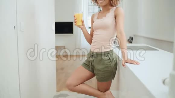 快乐混血女人在家喝橙汁视频的预览图