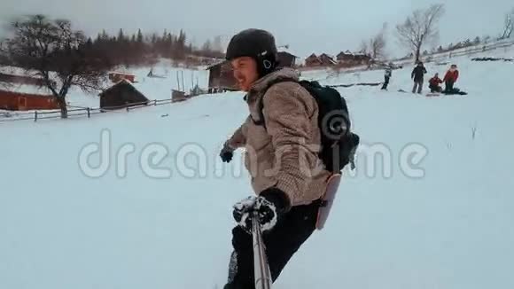 滑雪者在爬山时自拍滑雪者在雪地里骑在木板上放松自己视频的预览图