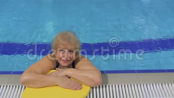 在游泳池里微笑的高级女人视频的预览图