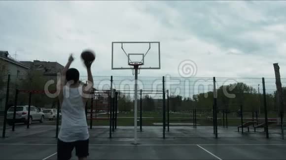 一个人把篮球扔进拳击场去户外视频的预览图