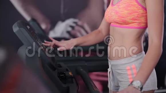 非常漂亮的健身模式是在健身房的跑步机上训练视频的预览图