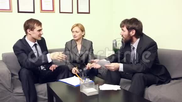 三位同事在办公室讨论商业计划视频的预览图