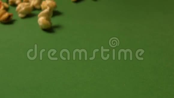 绿色背景下的爆米花慢动作特写镜头垂直平底锅3射击视频的预览图