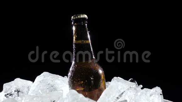 人从冰上拿一瓶啤酒黑色背景快关门慢动作视频的预览图