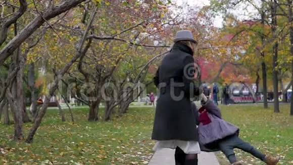 一个年轻的女人和她的女儿在公园里散步妈妈是个孩子视频的预览图