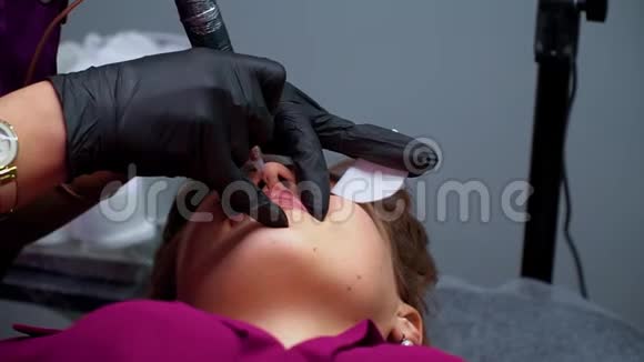 美容师在嘴唇上涂上永久的化妆品永久补偿视频的预览图