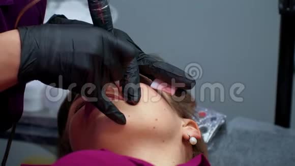美容师在嘴唇上涂上永久的化妆品视频的预览图