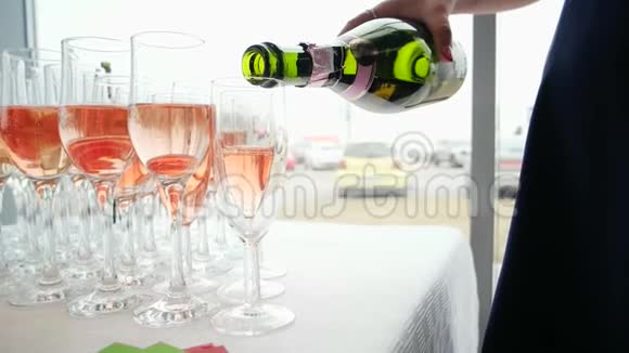 汽水从瓶子里倒出玻璃杯女人手拿瓶子倒出玫瑰香槟视频的预览图