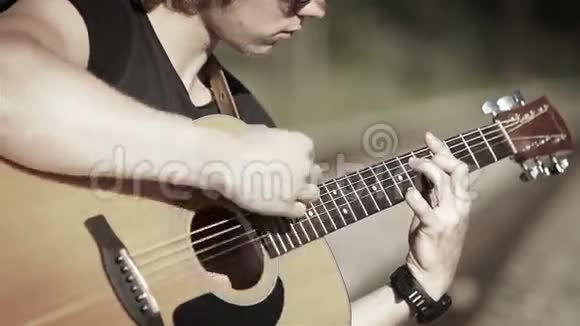 一位长发吉他手用简单的和弦弹唱一首歌的白镜头视频的预览图