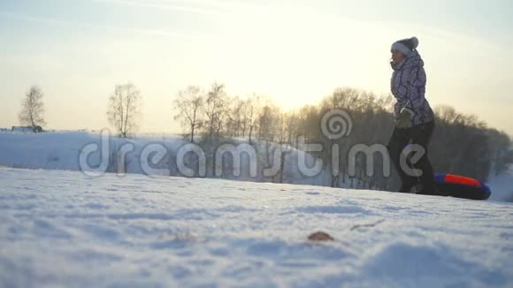 在冬天年轻的女人在山上缓慢地在阳光下奔跑玩得很开心1920x1080视频的预览图