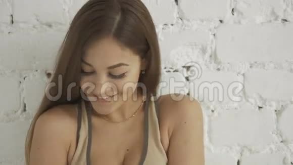 幸福年轻健身女性在白色砖墙背景下跳舞的肖像视频的预览图