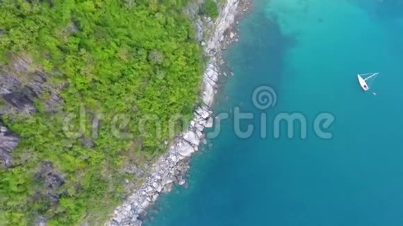 小船在清澈的蓝色水旁边的秘密努伊海滩与石头和棕榈树泰国普吉岛高清天线视频的预览图