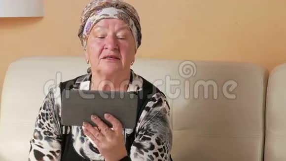 老年妇女咳嗽并在视频会议上与医生沟通在线平板电脑上的医生视频的预览图