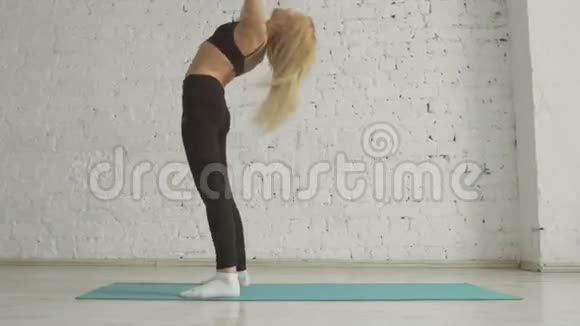 美丽的年轻女子做瑜伽运动伸展站在桥牌姿势视频的预览图