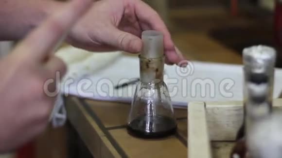 在化学实验中用吸管和烧瓶把科学家的手合上视频的预览图