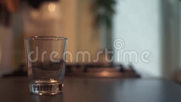 手把水从厨房桌上的罐子里倒入玻璃杯视频的预览图
