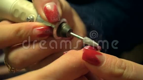 女孩用喷嘴去除指甲上的凝胶清漆视频的预览图