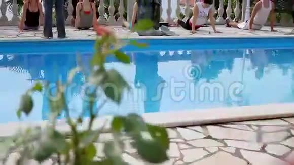 模特们用前面的游泳池和背景的大海锻炼身体视频的预览图