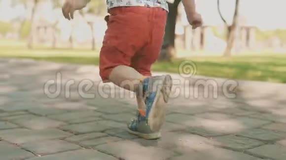 小男孩跑到外面儿童在公园跑步的慢动作视频的预览图