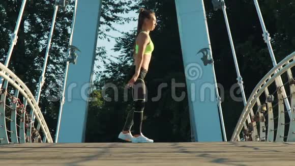 活跃的女性在城市公园的人行天桥上锻炼和伸展视频的预览图
