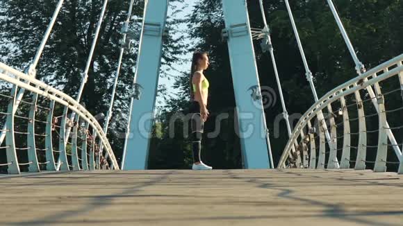 活跃的女性在城市公园的人行天桥上锻炼和伸展视频的预览图
