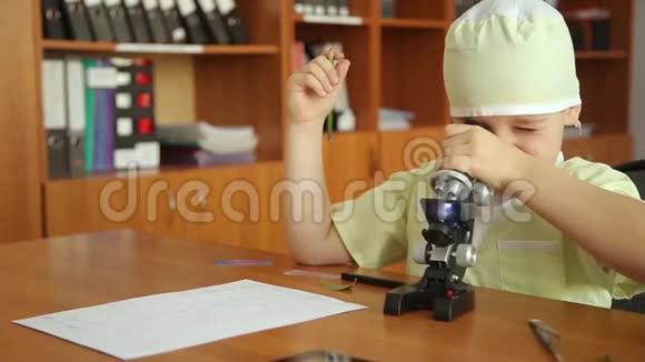 一个在实验室里拿显微镜的小男孩视频的预览图