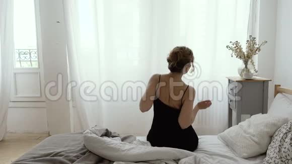 女人坐着伸展身体的后视图视频的预览图
