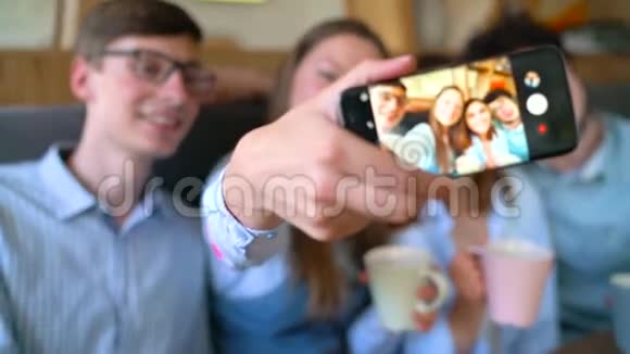 微笑的朋友坐在咖啡馆里有乐趣的交流和自拍慢动作视频的预览图