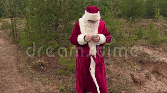 圣诞老人带着礼品袋和欧元钞票在森林里视频的预览图