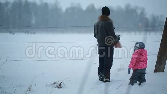 父亲和女儿在冬天靠近马厩视频的预览图