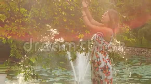 背光侧景金发女孩在公园靠喷泉做自拍视频的预览图