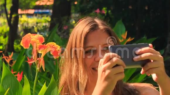 在公园里特写金发女郎让自拍对抗花朵视频的预览图