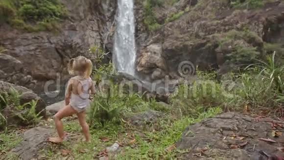 穿泳装照片的小女孩带电话瀑布视频的预览图