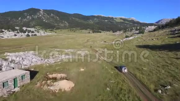 吉普车在克罗地亚迪纳拉山上经过一个石仓的鸟瞰图视频的预览图