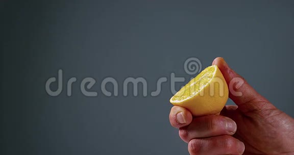 男人的手在黑色背景下压榨柠檬柑橘柠檬视频的预览图