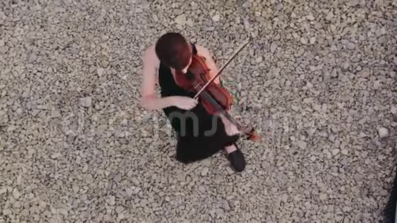 美丽的年轻女子在屋顶上拉小提琴视频的预览图