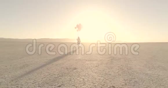 一个女孩带着气球在沙漠湖El幻影中行走空中无人机2017年10月视频的预览图