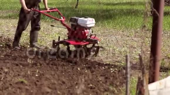 花园里的耕耘者要近距离工作走在拖拉机后面视频的预览图