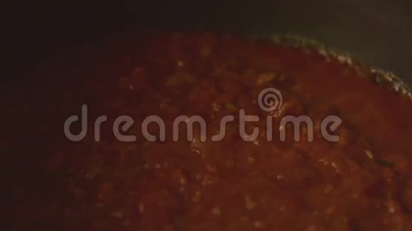煮番茄酱用勺子拌匀视频的预览图