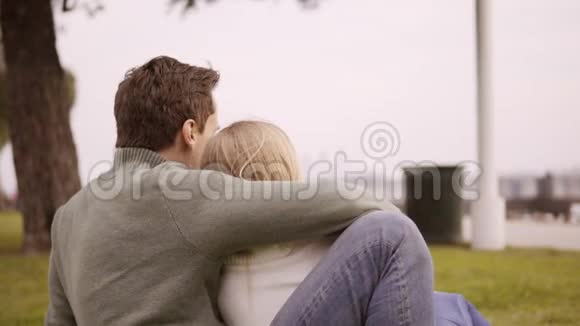 一对相爱的情侣在公园里拥抱一个靠近海洋的愉快夜晚视频的预览图
