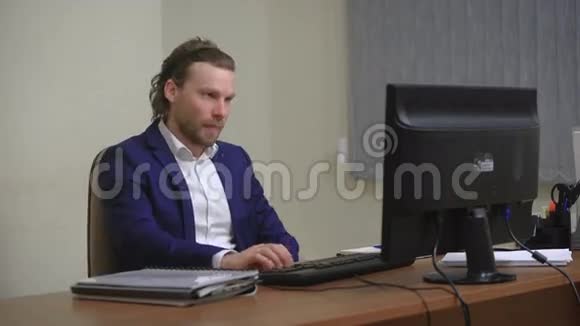 活跃的商人为成功感到高兴在办公室坐在电脑前视频的预览图