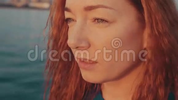 红发女孩在摩托艇上航行的肖像美丽的日落放松点微笑视频的预览图