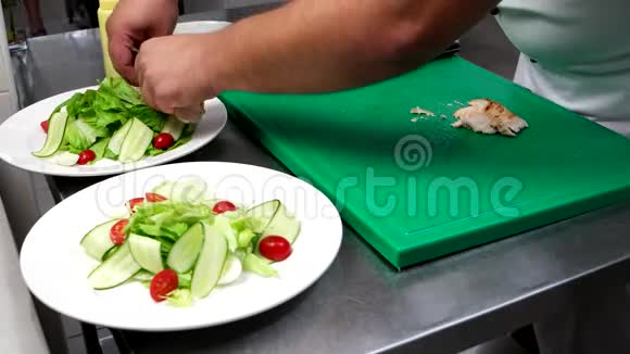 专业烹饪把炸鸡片放在蔬菜切片上樱桃番茄蔬菜黄瓜生菜视频的预览图