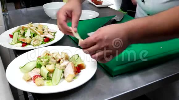 凯撒沙拉厨师把奶酪帕尔马干酪放在酱汁和切碎的蔬菜上鸡肉樱桃番茄生菜做菜视频的预览图