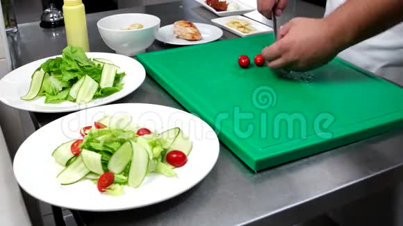 厨师切樱桃西红柿蔬菜黄瓜生菜放在盘子里职业厨房厨师准备一个视频的预览图