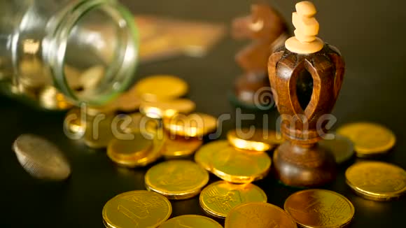用黑桌上的金币和旋转的便士来特写静止的生活黄色的硬币从罐子里掉了出来视频的预览图