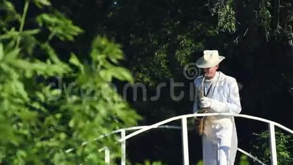 穿着白色连衣裙和帽子的萨克斯演奏家在桥上演奏视频的预览图
