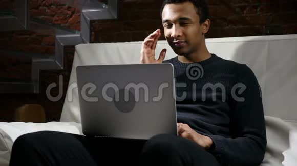 紧张头痛沮丧的非洲男人在笔记本电脑上工作视频的预览图